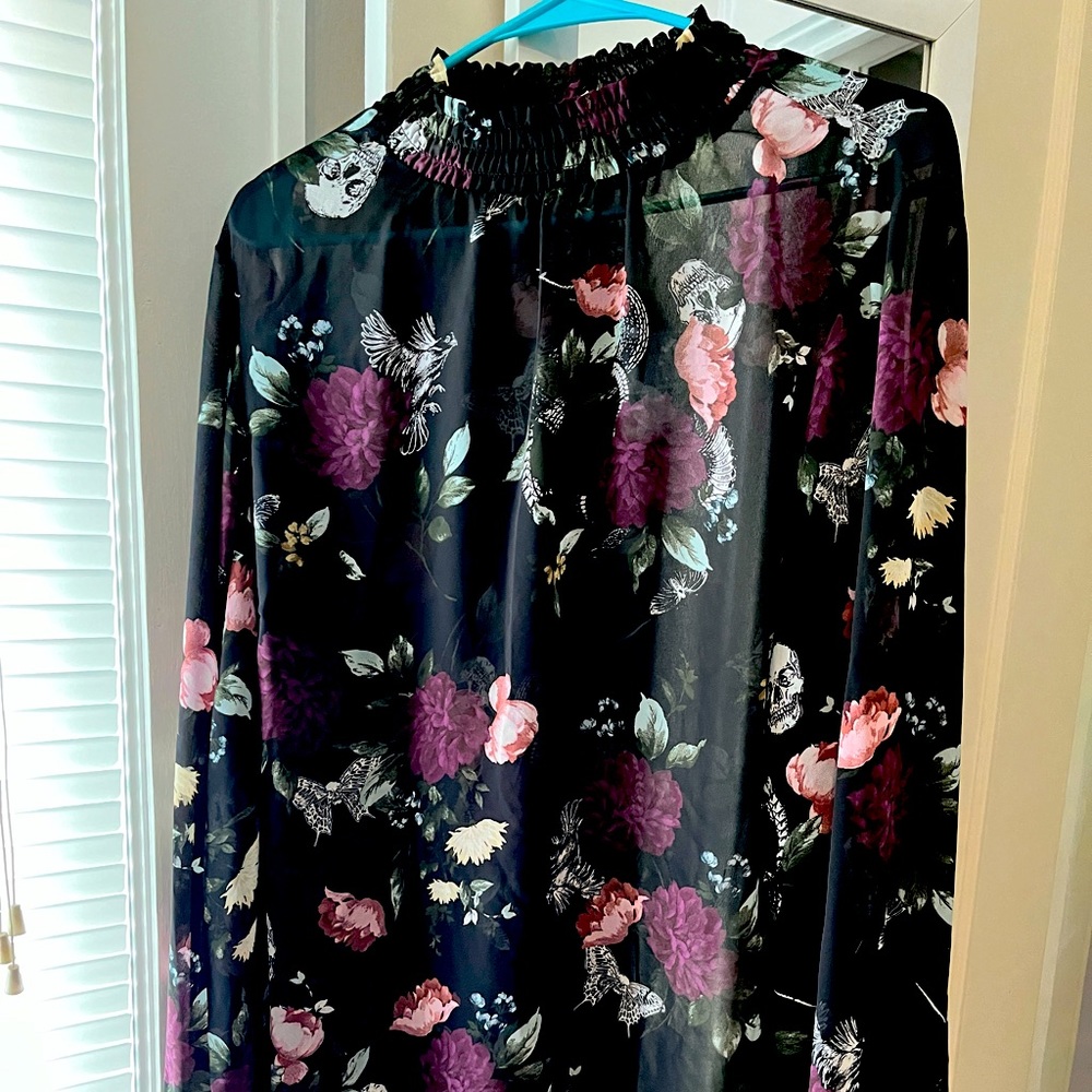 Sheer blouse with flower and skull detail.